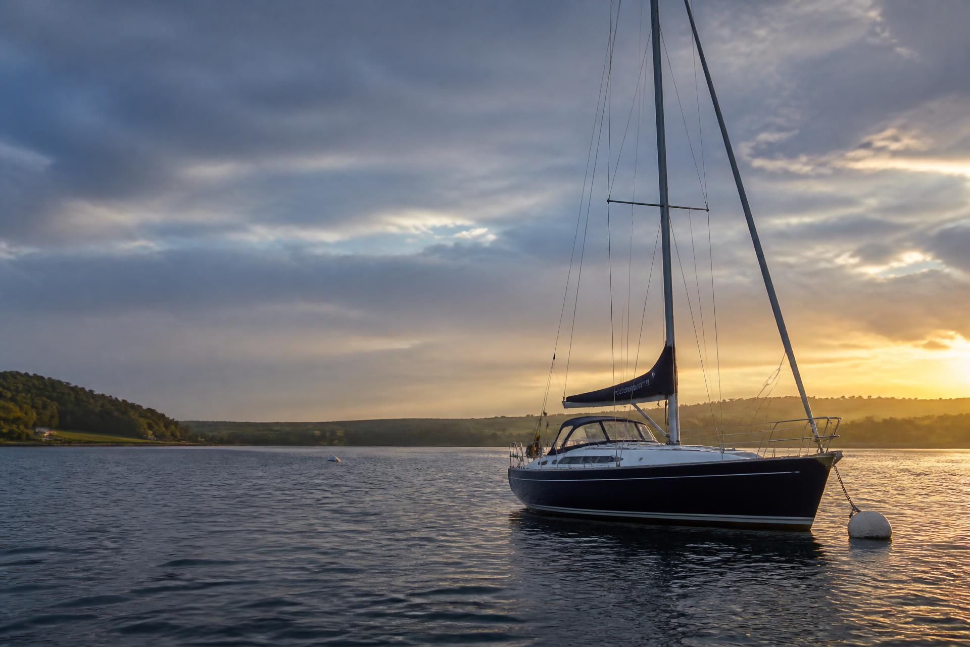 Sailing yacht at anchor in a calm British estuary at sunset